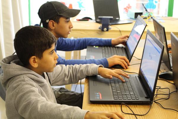 Image of two children using laptops