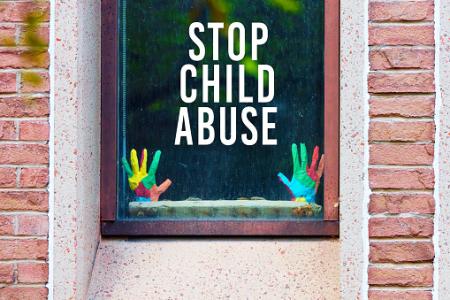 Stop child abuse written on the window. 