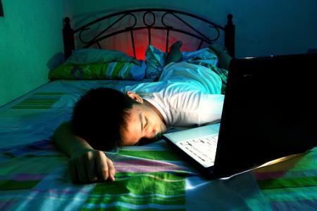 Young Teen sleeping in front of a laptop computer and on a bed