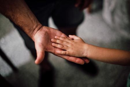 Adult handing hand to child
