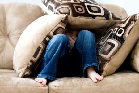 boy on couch protected by cushions