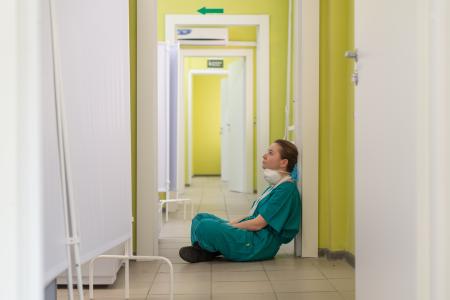 A nurse sitting on the floor of a hospital