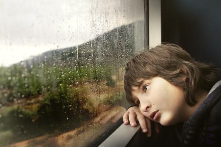  child sitting next to a window